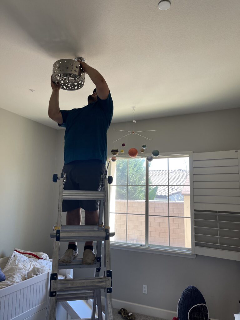 man installing light fixture