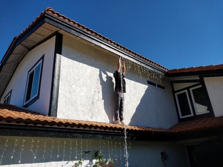 man hanging Christmas lights